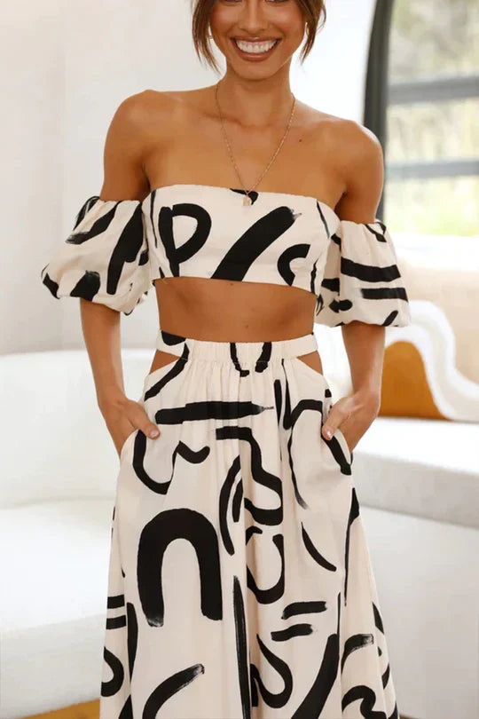 Bijpassende set met bedrukte off-shoulder top en maxirok met uitsnijdingen en zakken, perfect voor een coole en modieuze zomerse look